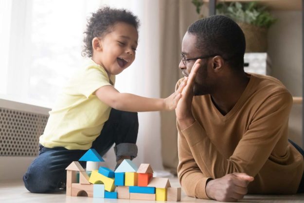 what-are-development-milestones a man plays with his son as he wonders what are development milestones