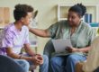 older female therapist helping young man with occupational therapy for autism
