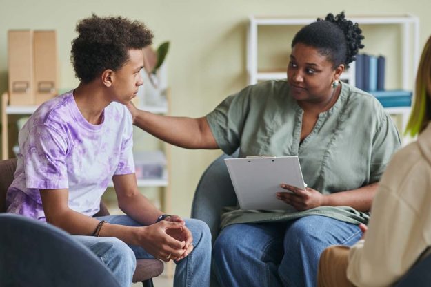 Occupational Therapy for Autism older female therapist helping young man with occupational therapy for autism