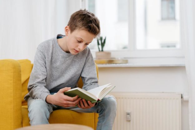 Autism and School Performance a boy reading a book about autism and school performance