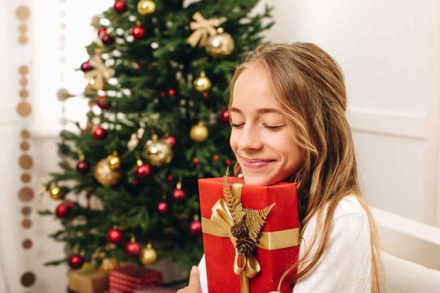 5 Holiday Gift Ideas for Children With Autism child opens holiday gifts