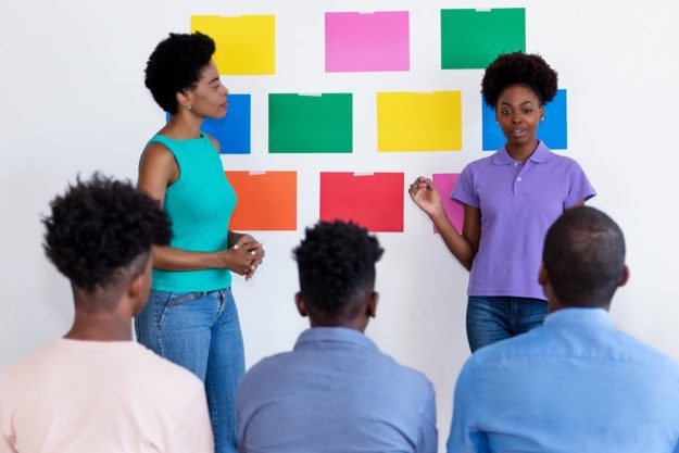 Goals of Speech Therapy two women showing colors to 3 males
