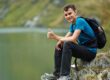 adolescent male child sitting by lake giving thumbs up as he participates in one of 5 autism friendly activities