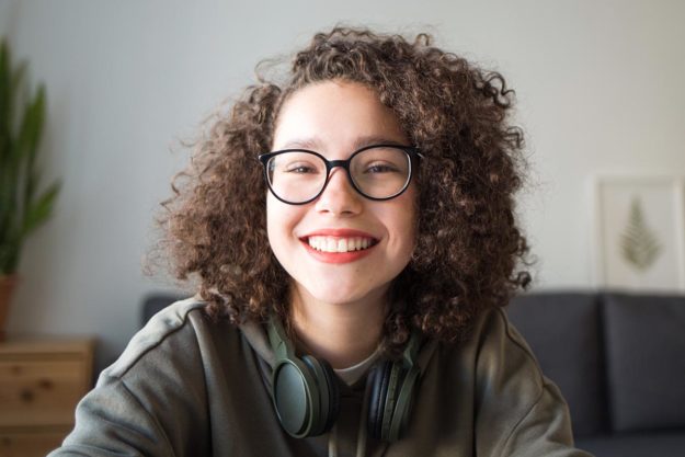 Neurotypical Vs Neurodivergent What the Difference smiling young woman with glasses asking neurotypical vs. neurodivergent what's the difference